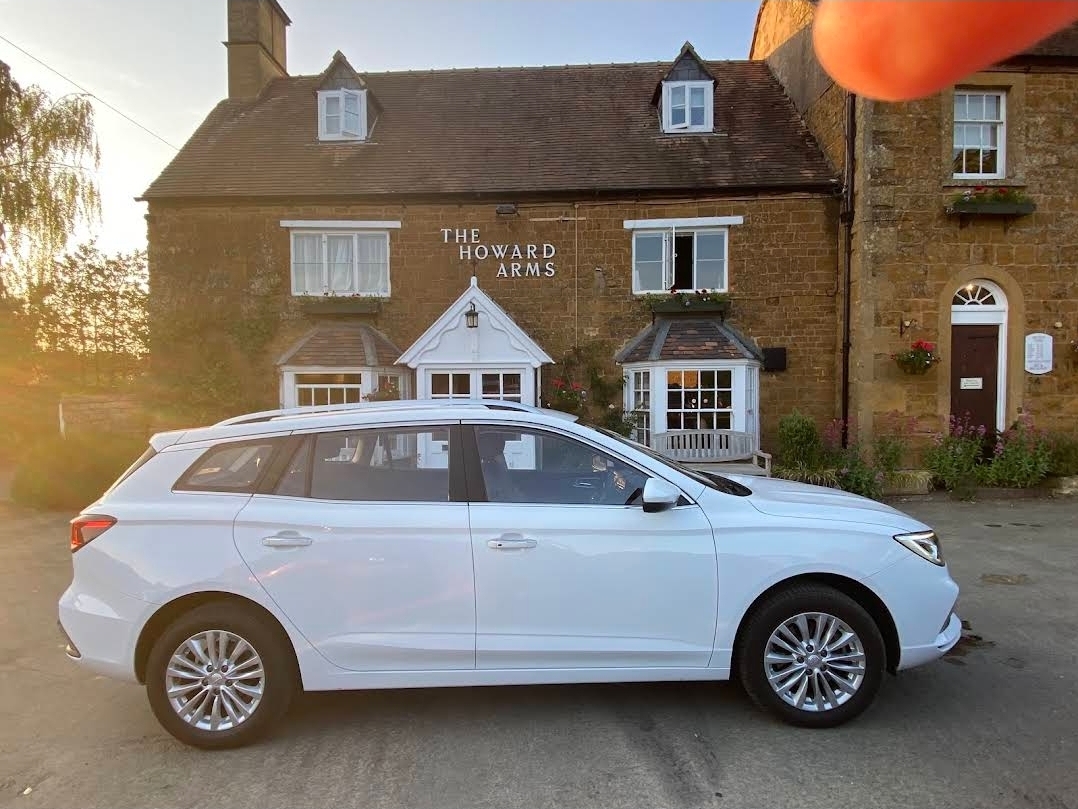 1st Area Cars electric estate car outside The Howard Arms, a Cotswold stone pub